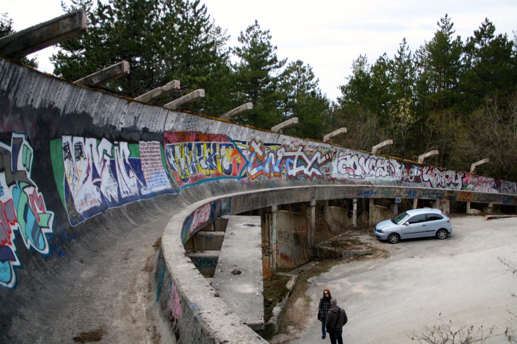 Oude Olympische bobsleebaan op de Trebević-berg bij Sarajevo, met betonnen bochten omgeven door bos en sporen van renovatie door freeriders