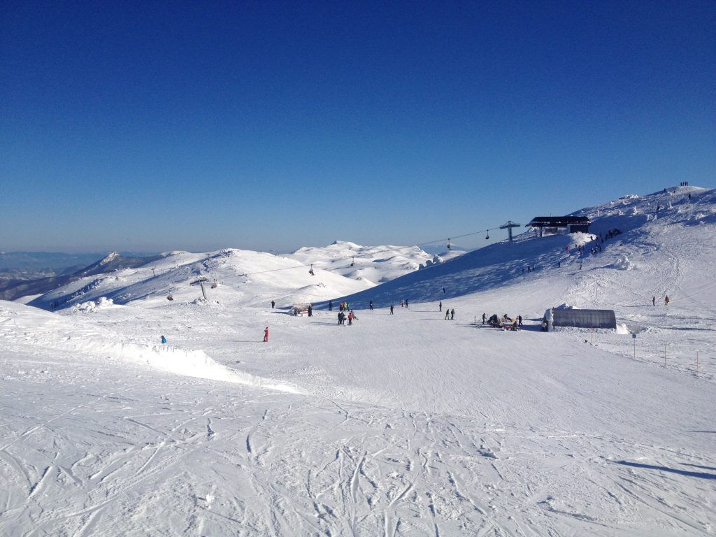 Uitzicht vanaf Jahorina, met hellingen bedekt met witte sneeuw en een helder winterlandschap