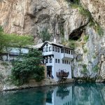 Uitzicht op de historische Dervish Tekija in Blagaj, gelegen aan de bron van de rivier de Buna, omringd door steile kalkstenen kliffen.