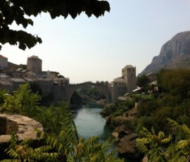 Uitzicht op de beroemde Stari Most ('Oude Brug'), de historische stenen boogbrug in Mostar, die de rivier Neretva overspant en symbool staat voor de stad en haar rijke geschiedenis. Uitzicht op Stari Most, de oude brug van Mostar, vanuit de verte gezien