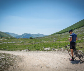 Mountainbiker in de bergen van Bosnië en Herzegovina die zijn Garmin gebruikt om een MTB-route te navigeren.